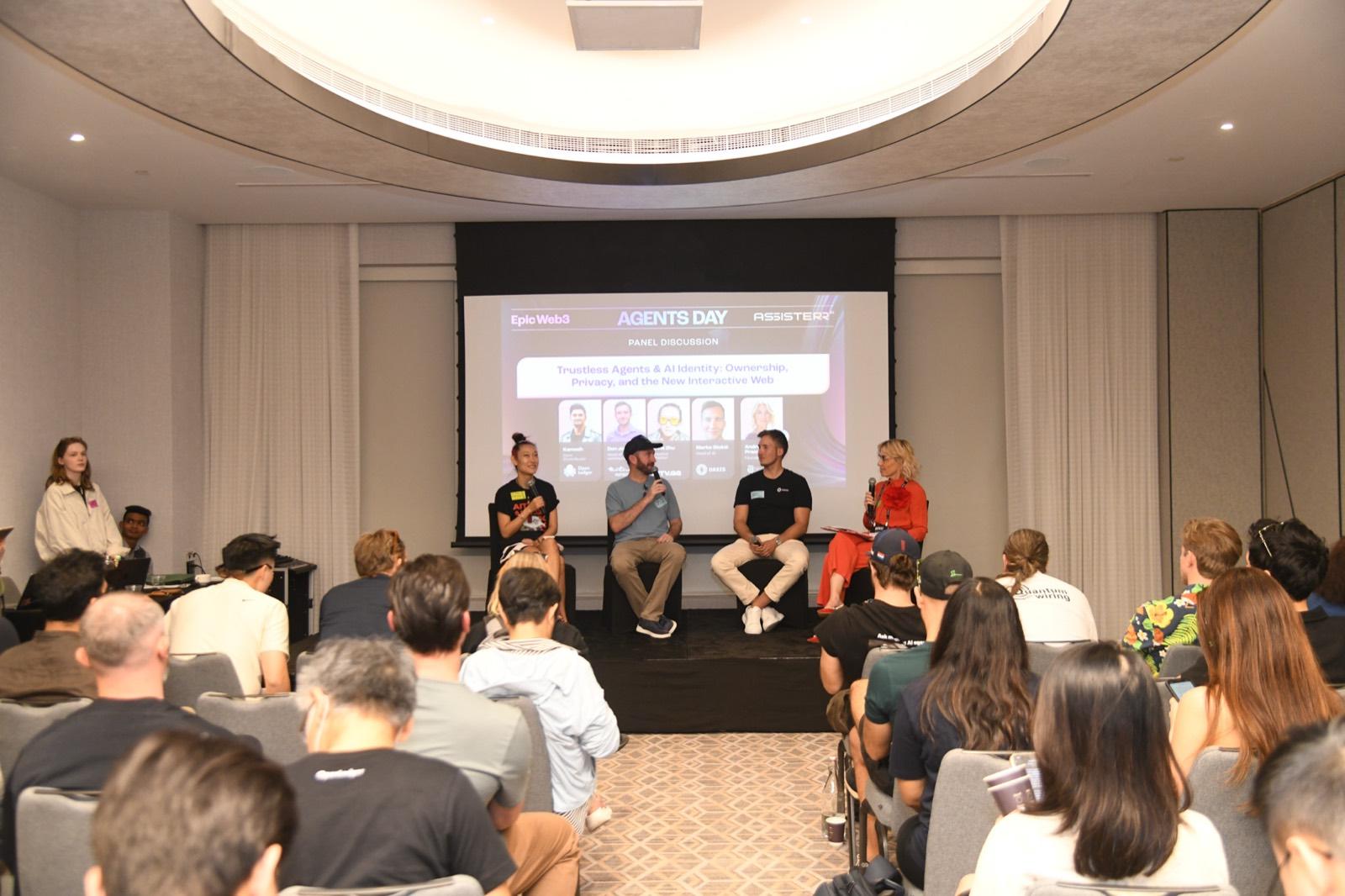 A large seated audience watching a panel discussion on stage at Agents Day