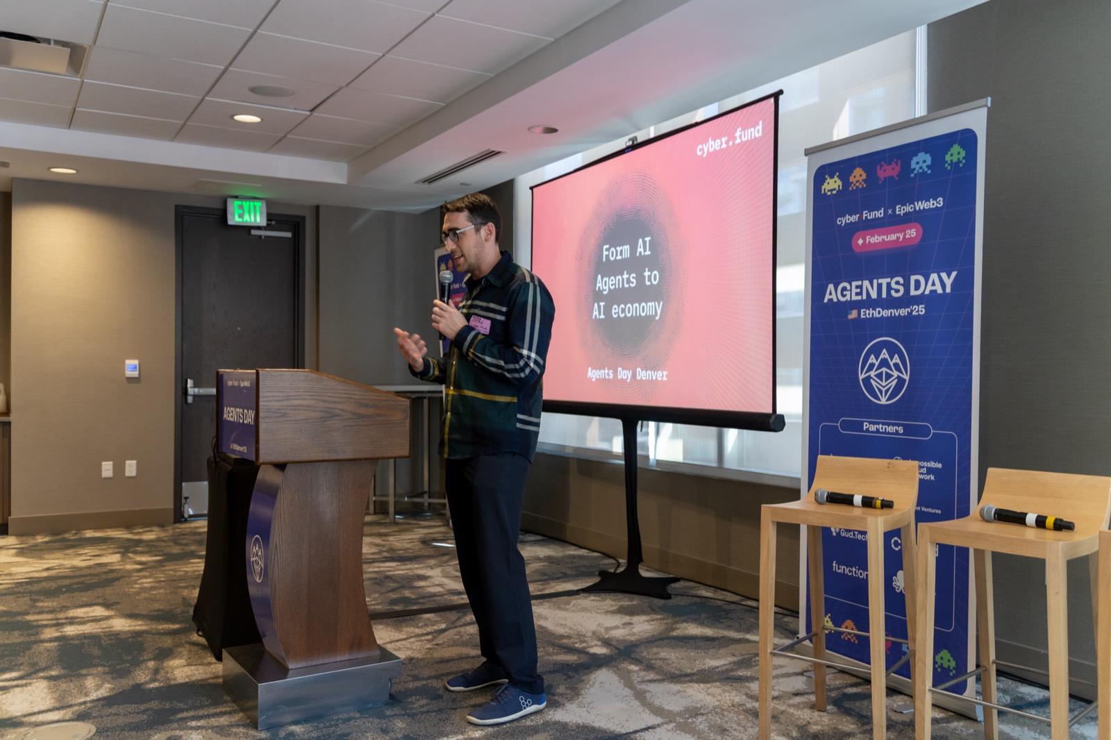 The welcome speech at Agents Day beside event branding
